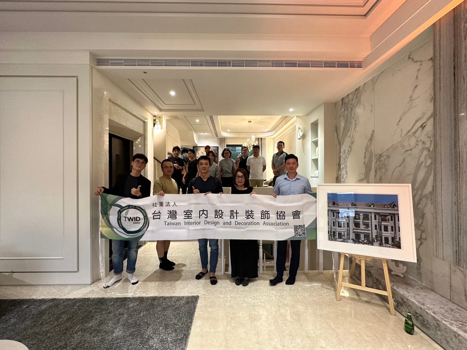 協會會員手持 TWiD 橫幅在住宅空間合影
