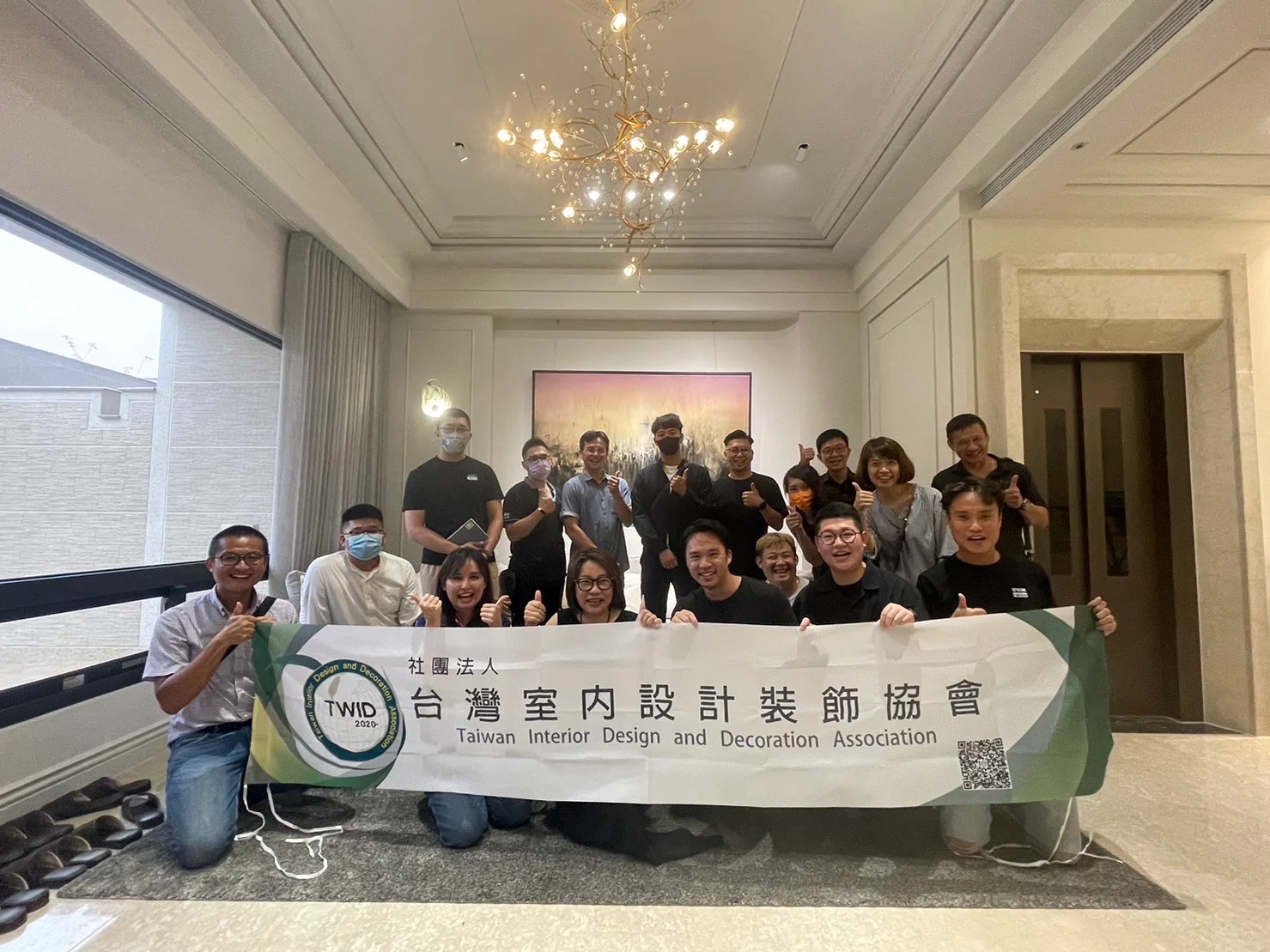 協會夥伴與 TWiD 橫幅在住宅內合影