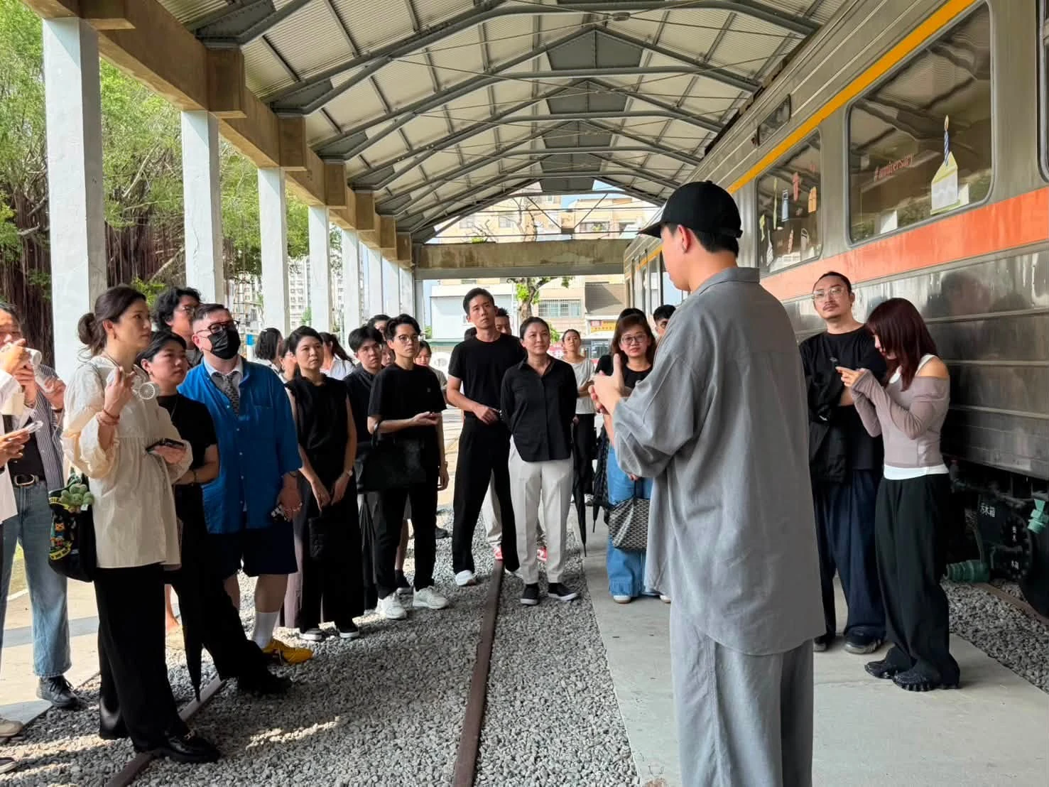 會員在保存列車旁聆聽導覽人員介紹場域特色